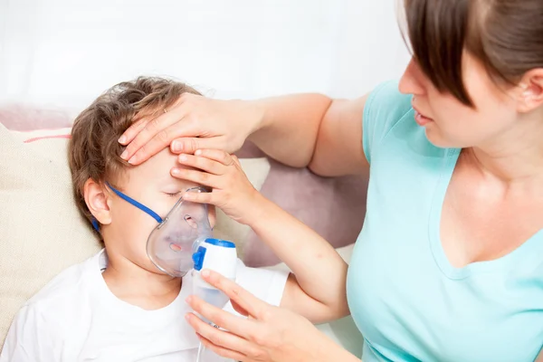 Genç kadının oğlu ve dokunur bir Nebulizatör ile enhalasyon yapması alnına