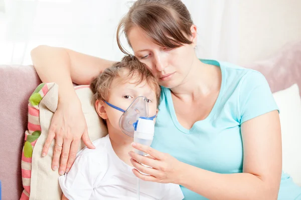 Fiatal nő fiával, csinál egy nebulizátor otthon a belégzés Stock Kép