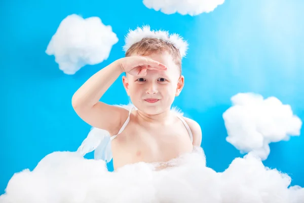 Pojke Cupid sitter på ett moln med en pil i hand — Stockfoto