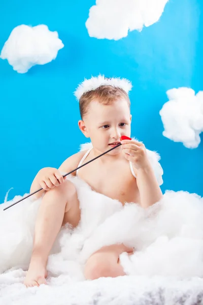 Pojke Cupid sitter på ett moln med en pil i hand — Stockfoto