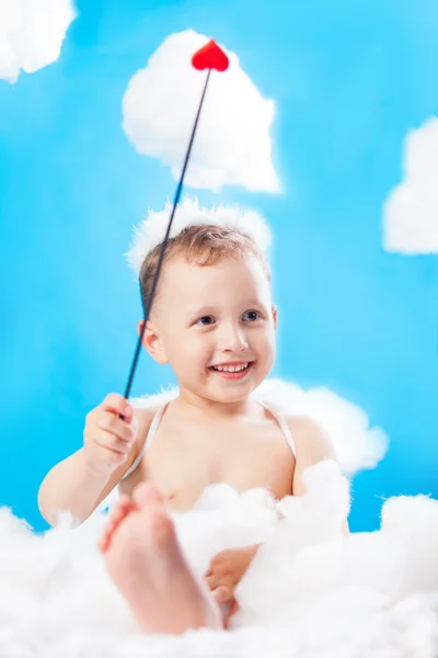 Menino Cupido sentado em uma nuvem com uma seta na mão — Fotografia de Stock