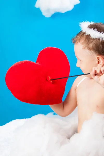 Menino Cupido em uma nuvem com uma seta através do coração vermelho — Fotografia de Stock