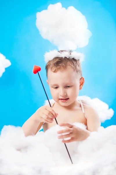 キューピッド赤いハートを矢で雲の上の少年 — ストック写真