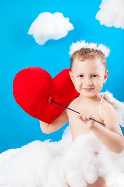 Boy Cupid on a cloud with an arrow through red heart Stock Picture