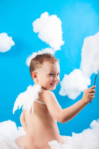 Pojke Cupid sitter på ett moln med en pil i hand — Stockfoto