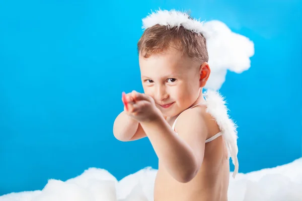 Pojke Cupid sitter på ett moln med en pil i hand — Stockfoto