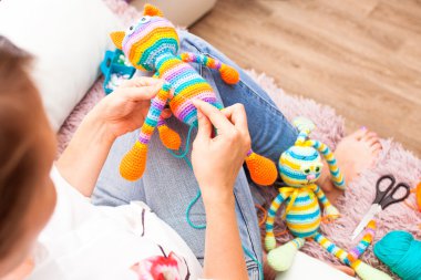 Genç kadın oyuncak amigurumi bacak dikmek için iğne işi, nişanlandı
