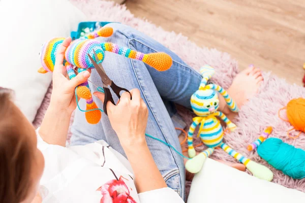 Jonge vrouw houdt zich bezig met naaien, naaien speelgoed amigurumi been — Stockfoto