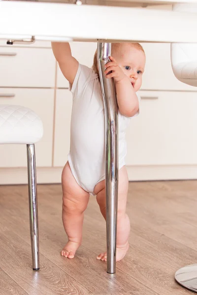 Niño camina debajo de la mesa —  Fotos de Stock