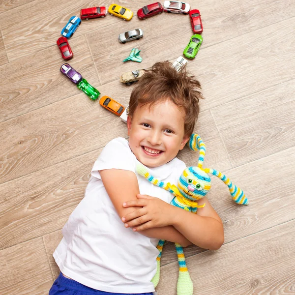 Niño feliz jugando en el suelo con juguetes —  Fotos de Stock