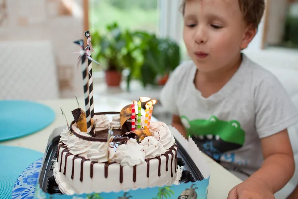 Το αγόρι κάθεται με την τούρτα στο τραπέζι και δείχνει πόσο χρονών ήταν — Φωτογραφία Αρχείου