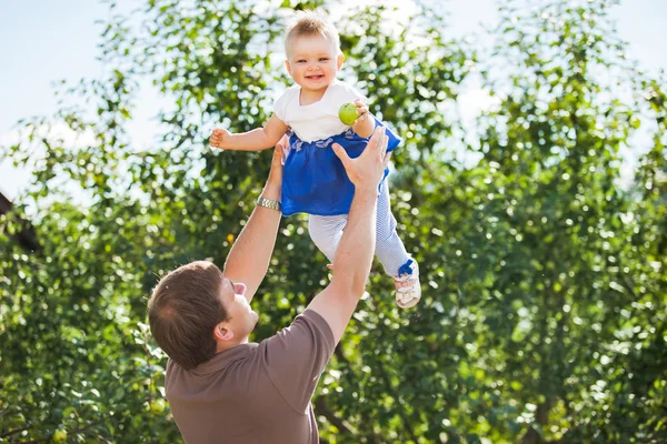 Молодий дбайливий тато високий кидає маленьку дочку в парк — стокове фото