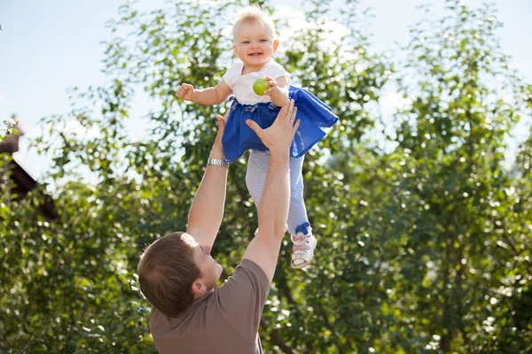 Jeune papa attentionné jette la petite fille dans le parc — Photo