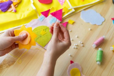 Güneşi hisseden kadın elleri. Tahta masadaki dikiş işleri için aksesuarlar. Çocuklar ve yetişkinler için bahar ya da yaz el sanatları fikri. Oda dekorasyonu için yaratıcı DIY. en üstteki görünüm.
