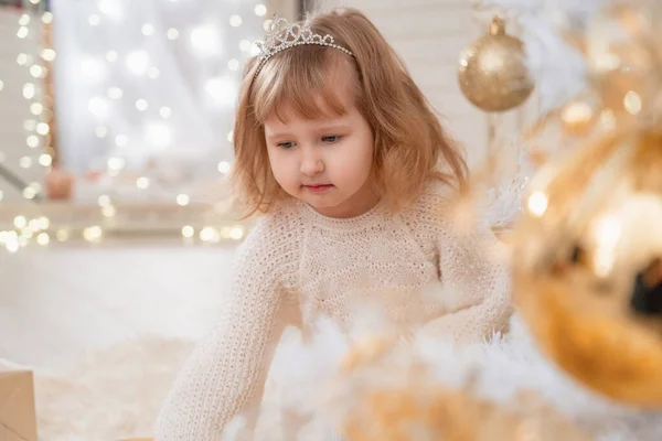 크리스마스와 즐거운 드레스에 뜨개질을 소녀가 화이트 크리스마스 근처에 있습니다 장난감이 — 스톡 사진