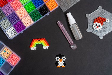 Oyuncak gökkuşağı figürü toplardan oluşur, siyah bir arka planda. El yapımı çocuklar, el yapımı su mozaiği masada, seçici bir odak noktası. Yeni yıl ve Noel konsepti