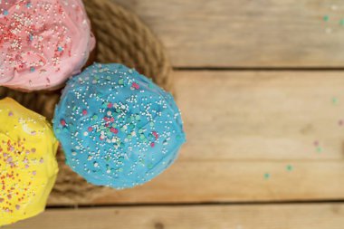 Odadaki masanın üzerinde renkli yumurtalar olan Paskalya pastaları. Bayram için geleneksel Ortodoks hamur işleri. Arka plan bulanık. Seçici odaklanma. Yukarıdan manzara. Boşluğu kopyala.