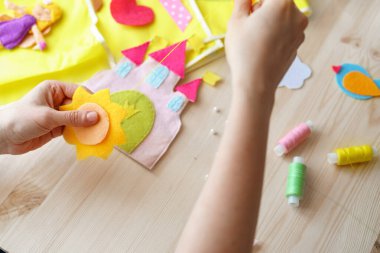 Güneşi hisseden kadın elleri. Tahta masadaki dikiş işleri için aksesuarlar. Çocuklar ve yetişkinler için bahar ya da yaz el sanatları fikri. Oda dekorasyonu için yaratıcı DIY. en üstteki görünüm.