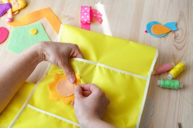Keçeden güneş yapan kadın ellerinin yakın çekimi. Tahta bir masada dikiş işi için aksesuarlar. Çocuklar ve yetişkinler için bahar ya da yaz işleri. Oda dekorasyonu için yaratıcı DIY.