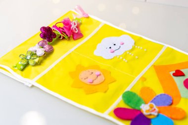 Anaokulu için cepler. Anaokulundaki çocuk dolabında depolama sistemi. Uygulamalar ve dekoratif öğeler keçeden dikilmiştir. Çocuklar ve yetişkinler için bahar ya da yaz el sanatları.