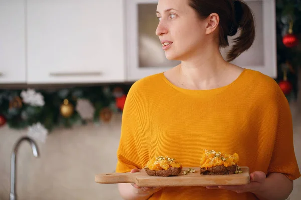 Женщина Держит Доску Вкусными Бутербродами Тыквы Сыром Семенами Кунжута Проросшими — стоковое фото