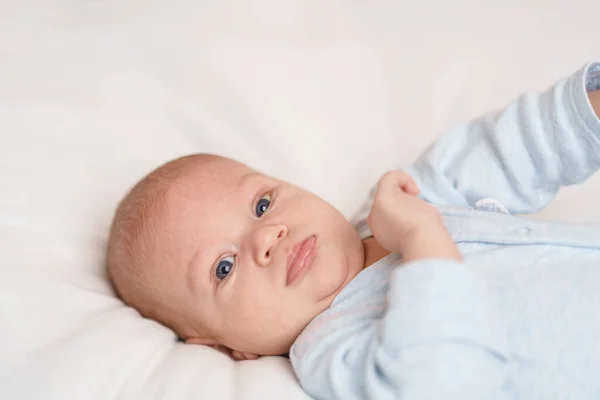Aylık Mavi Gözlü Mavi Elbiseli Beyaz Bir Bebek Sırt Üstü — Stok fotoğraf