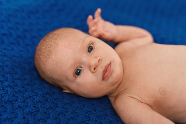 Aylık Mavi Gözlü Mavi Elbiseli Beyaz Bir Bebek Sırt Üstü — Stok fotoğraf