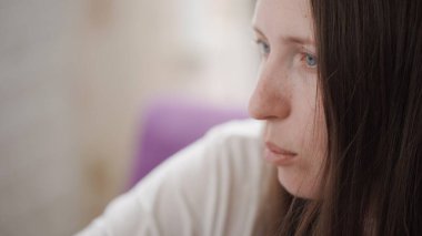 Kadının yüzü, bilgisayar ekranına yakından bakıyor. Kız sosyal ağlarda ve internet alanında sörf yapıyor. Konuşuyor ve düşünceli görünüyor.