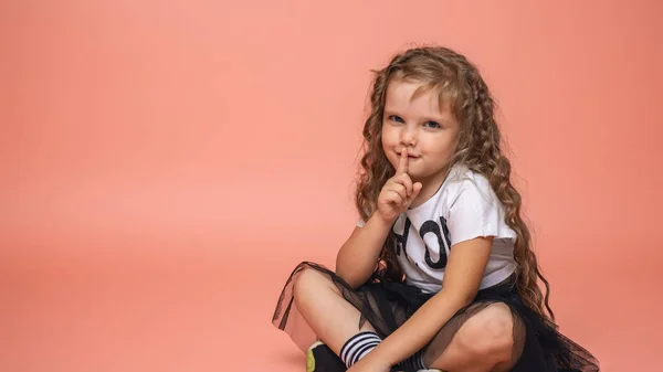 Κομψό Κοριτσάκι Ετών Σγουρά Μαλλιά Μοντέρνα Ρούχα Κάθεται Ροζ Φόντο — Φωτογραφία Αρχείου