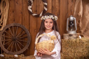 Kafasında çelenk olan beyaz elbiseli mutlu küçük bir kız büyük tüylü bir ördek yavrusuyla bir sepet tutuyor. Güzel kızlar neşeyle güler ve Paskalya ördekleri ile oynarlar. Paskalya Kompozisyonu