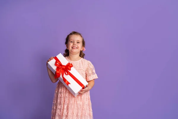 Μικρό Χαριτωμένο Κορίτσι Κουτί Δώρου Κόκκινη Κορδέλα Μωβ Φόντο Γενέθλια — Φωτογραφία Αρχείου