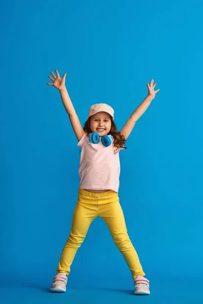 Glad Liten Flicka Fashionabla Sommarkläder Och Hörlurar Står Blå Bakgrund — Stockfoto