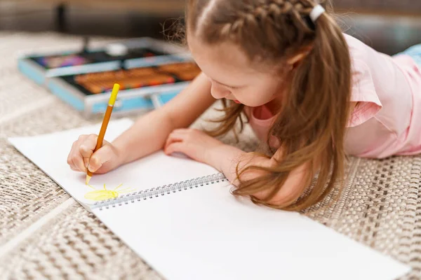 귀여운 아이가 연필로 바닥에 앨범에 그림을 그리고 있습니다 일하는 아이는 — 스톡 사진