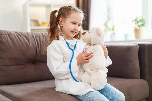 Niña Caucásica Gafas Uniforme Médico Blanco Está Tratando Oso Peluche —  Fotos de Stock