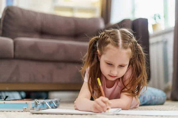 Маленькая Милая Белая Девочка Рисует Альбом Цветными Карандашами Лежащий Полу — стоковое фото