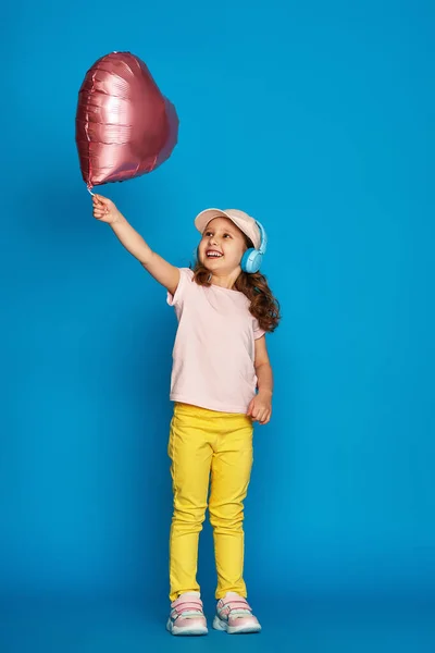 Μικρό Χαριτωμένο Κορίτσι Μοντέρνα Καλοκαιρινά Ρούχα Και Ακουστικά Κρατώντας Μπαλόνι — Φωτογραφία Αρχείου