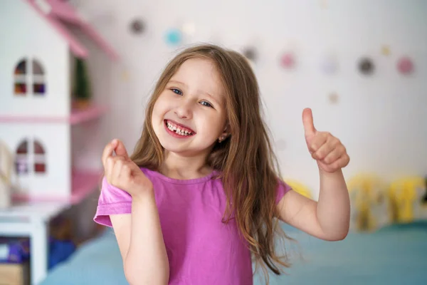 快乐的小女孩露出了掉下的乳牙 长出了恒牙 可爱的微笑的学龄前女孩手里拿着第一颗掉下的婴儿牙 幼儿牙齿卫生的概念 — 图库照片