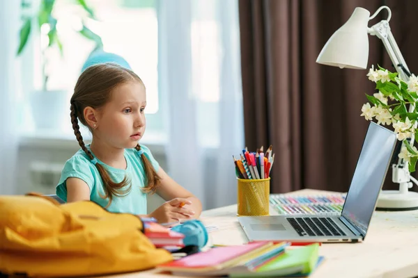 気配りのある少女はノートパソコンを使って先生とビデオ通話をします 子供は遠隔で学ぶことができます 女子高生は喜んで知識をもらう Education距離ホームラーニング — ストック写真