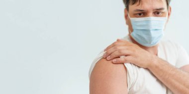 Aşılanmış bir adam, Coronavirus aşısı enjekte edildikten sonra elini bir bantla gösterir. Coronavirüs 'e karşı aşı reklamı. Boşluğu kopyala