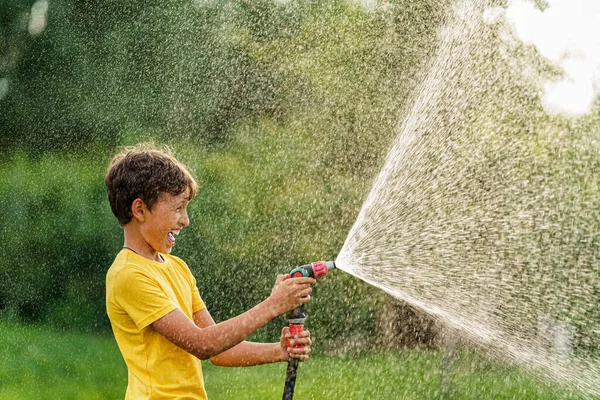 Fröhliche Junge Planscht Und Spielt Mit Gartenschlauch Mit Sprinkler Bei — Stockfoto