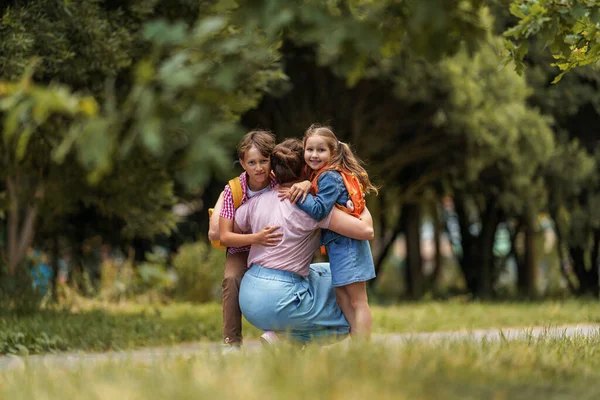Любящая Семья Заботливая Мать Встречает Веселых Детей Мальчика Девочку Рюкзаками — стоковое фото