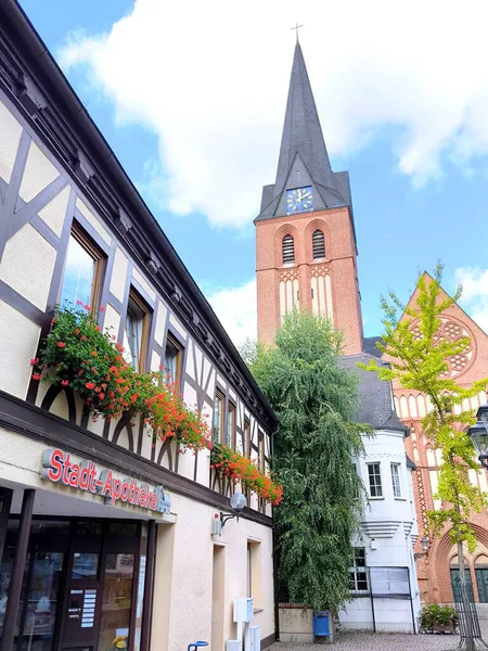 Bitterfeld, Almanya - 6 Eylül 2025: Alman kenti Bitterfeld 'in merkezi meydanı geleneksel yarı ahşap bir bina ve saat kulesi olan antik bir kilise.