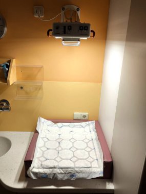 Üzerinde yumuşak bir yatak ve kızılötesi ısıtma lambası olan bir bebeği incelemek ve değiştirmek için belirlenmiş bir alan.