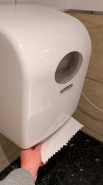 Schoenebeck, Almanya - Januar 24, 2026: Tuvalette otomatik veya elle kağıt havlu makinesi kullanma süreci. Ofis veya restoran gibi kamusal ortamlarda el hijyeni ve temizlik gösterimi.