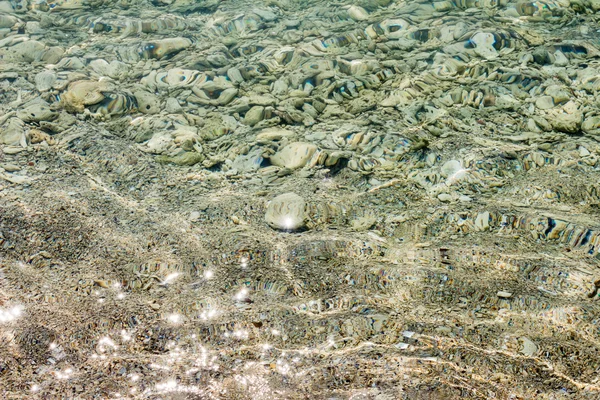 Sten, grus, sand, kristallklart havsvatten. — Stockfoto