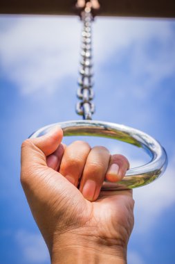hand in metal chains against the blue sky. clipart