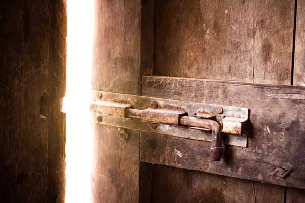 Old dark room with shining closed door. — Stock Photo, Image