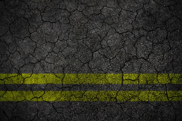 Spricka asfalt Road textur med gula remsan — Stockfoto