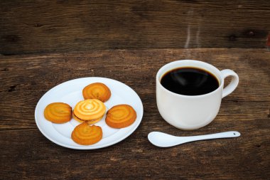 Ahşap masa arkasında bir fincan kahve.