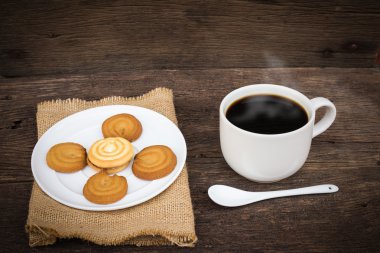 Ahşap masa arka plan üzerinde çul peçete üzerinde kahve